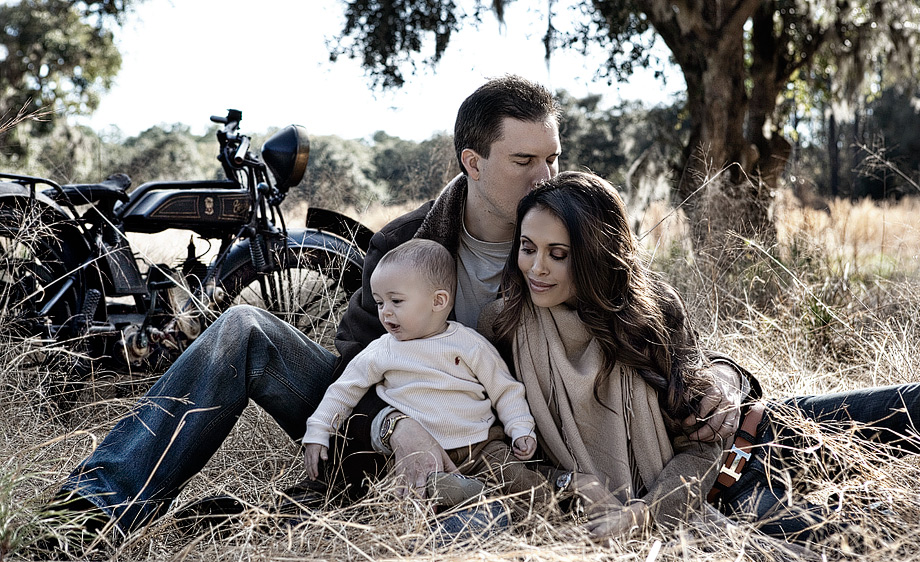 Palmetto Bluff family sitting in field with baby and antique bike