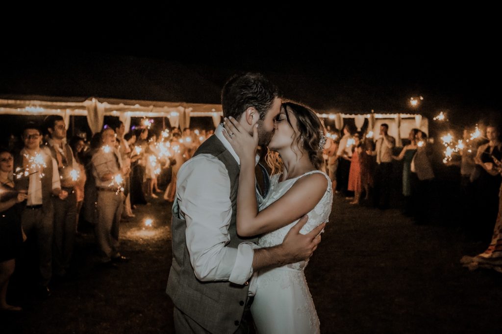 bride and groom kissing sparkler exit