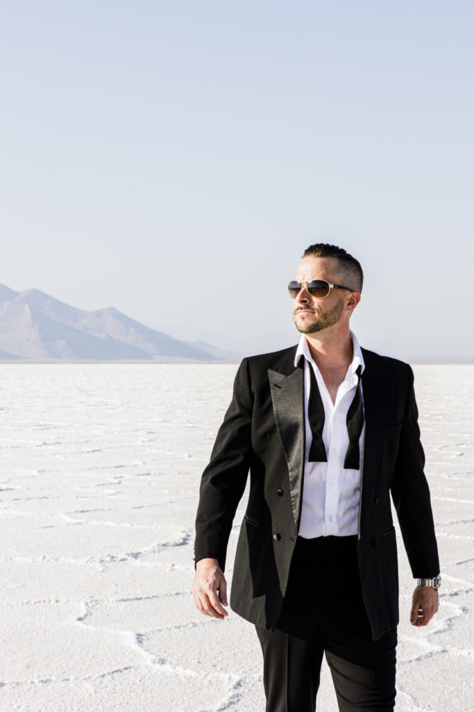 James Bond suiting on model on Salt Flats fixing collar