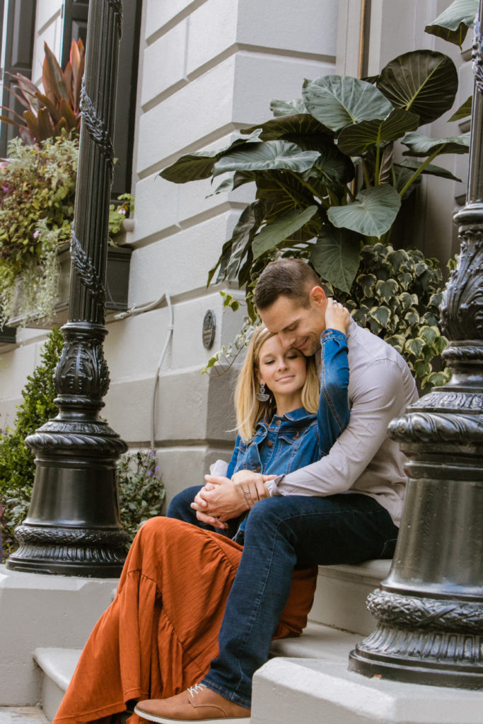 couple sitting and cuddling in Charleston for engagement photos