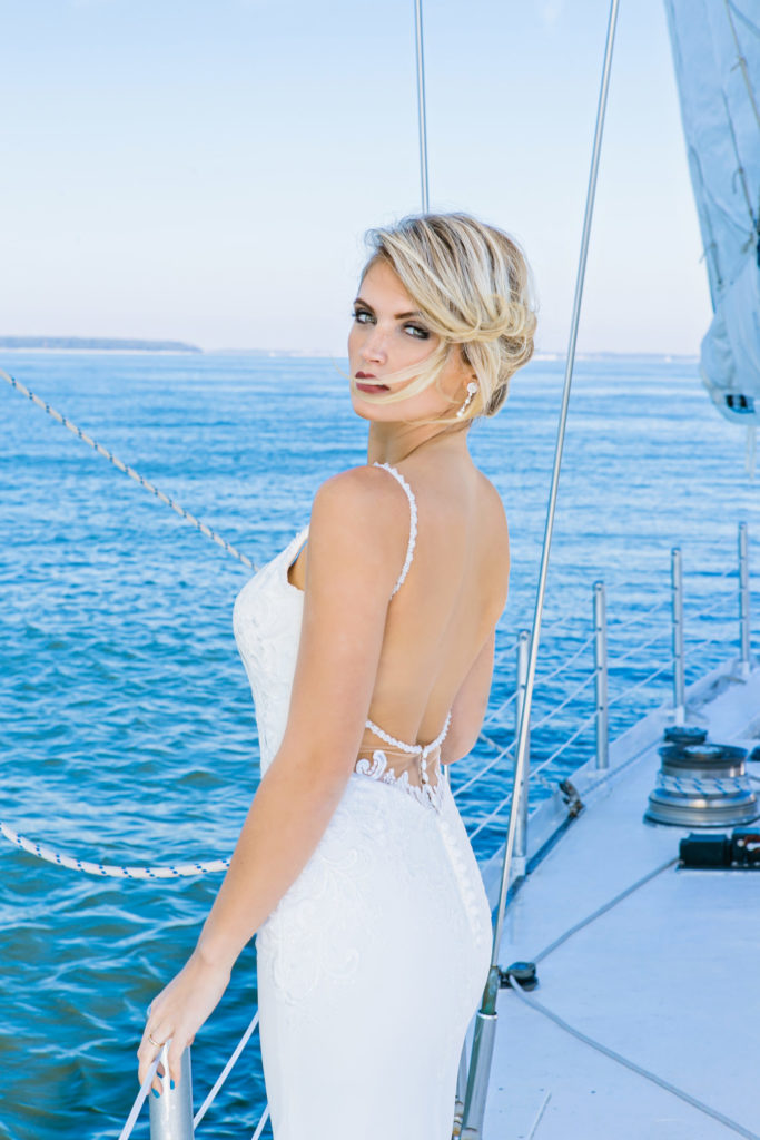 bride standing on bow of sailboat in a wedding dress on Hilton Head Island