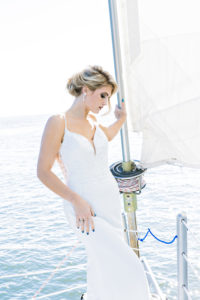 bride standing on bow of sailboat in a wedding dress on Hilton Head Island