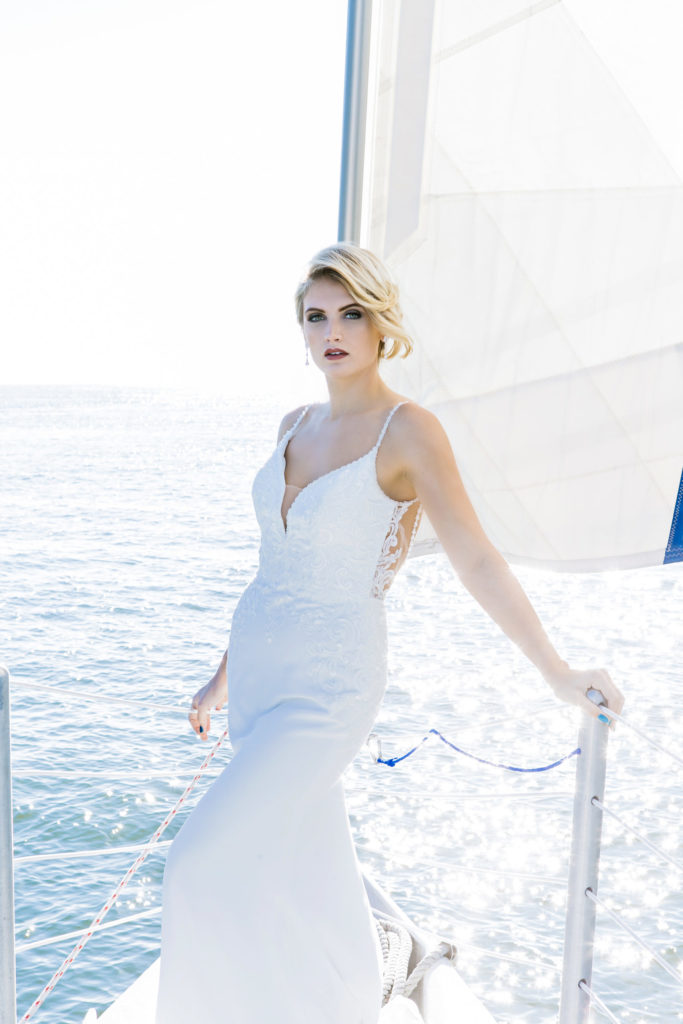 bride standing on bow of sailboat in a wedding dress on Hilton Head Island