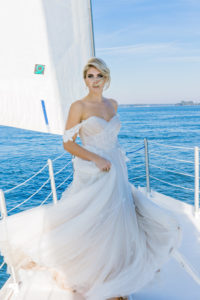 bride standing on bow of sailboat in a wedding dress on Hilton Head Island