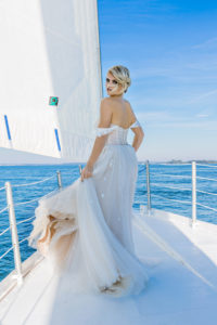 bride standing on bow of sailboat in a wedding dress on Hilton Head Island