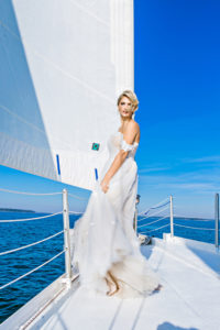 bride standing on bow of sailboat in a wedding dress on Hilton Head Island