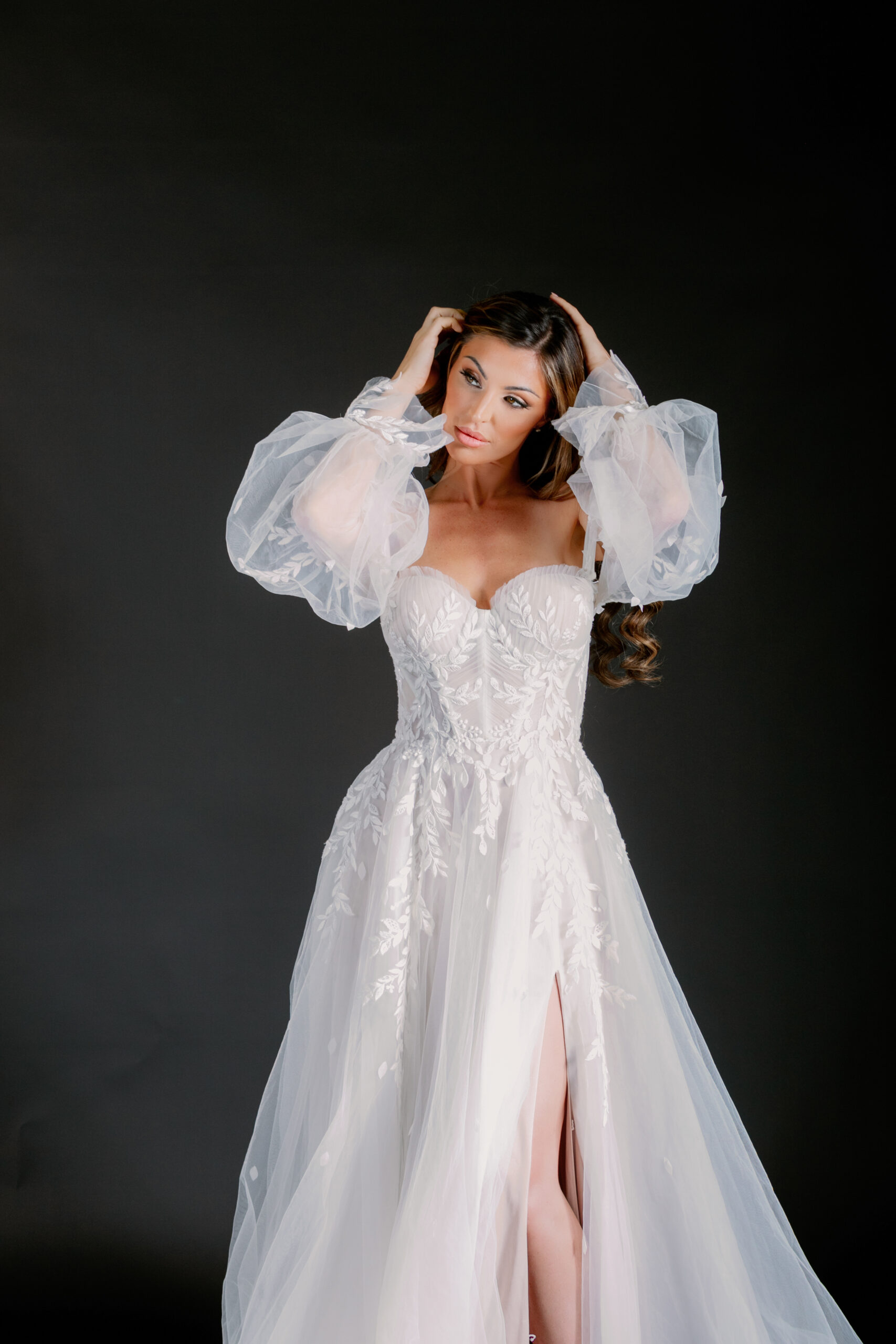 Bride in a gorgeous wedding gown on a black backdrop