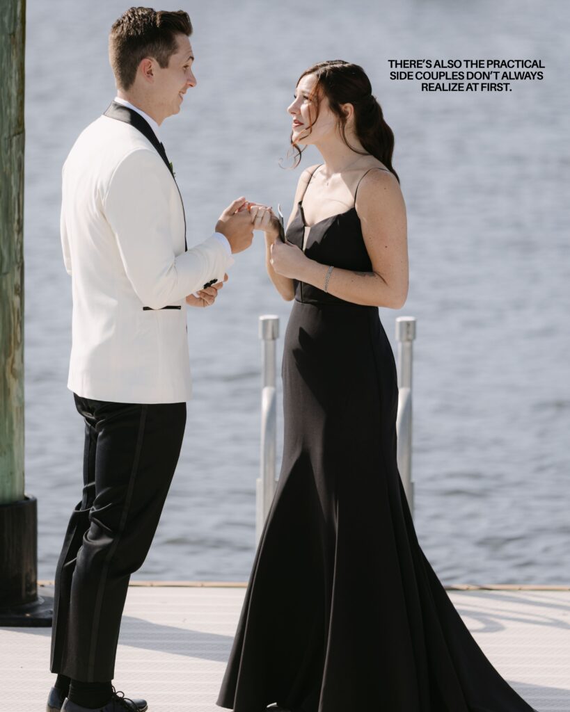 A couple having their first look before their wedding out on a dock in Charleston reading their vows to each other. He is in a white dinner jacket and she in a black gown