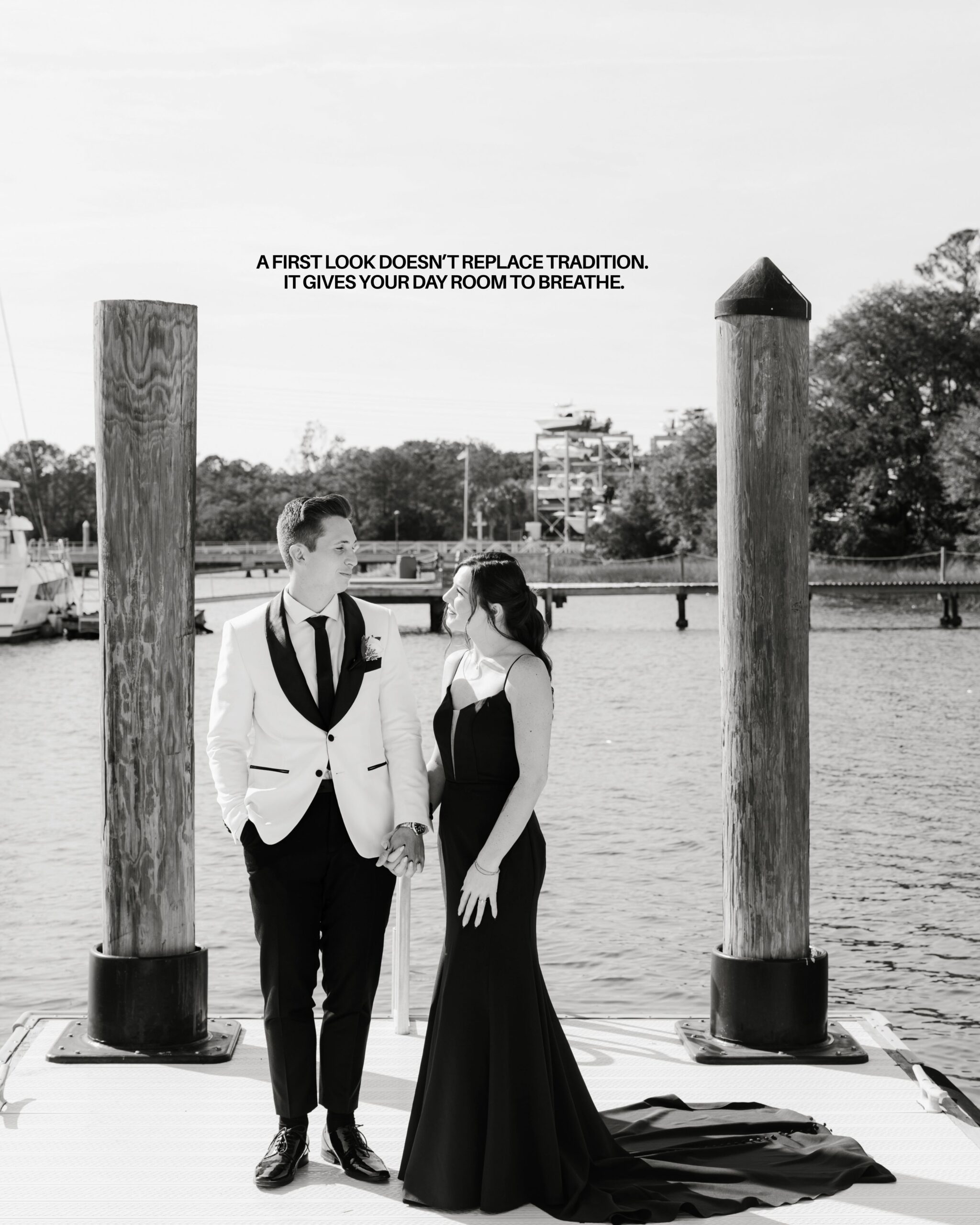 A couple having their first look before their wedding out on a dock in Charleston. the groom in a white dinner jacket and the bride in a black gown