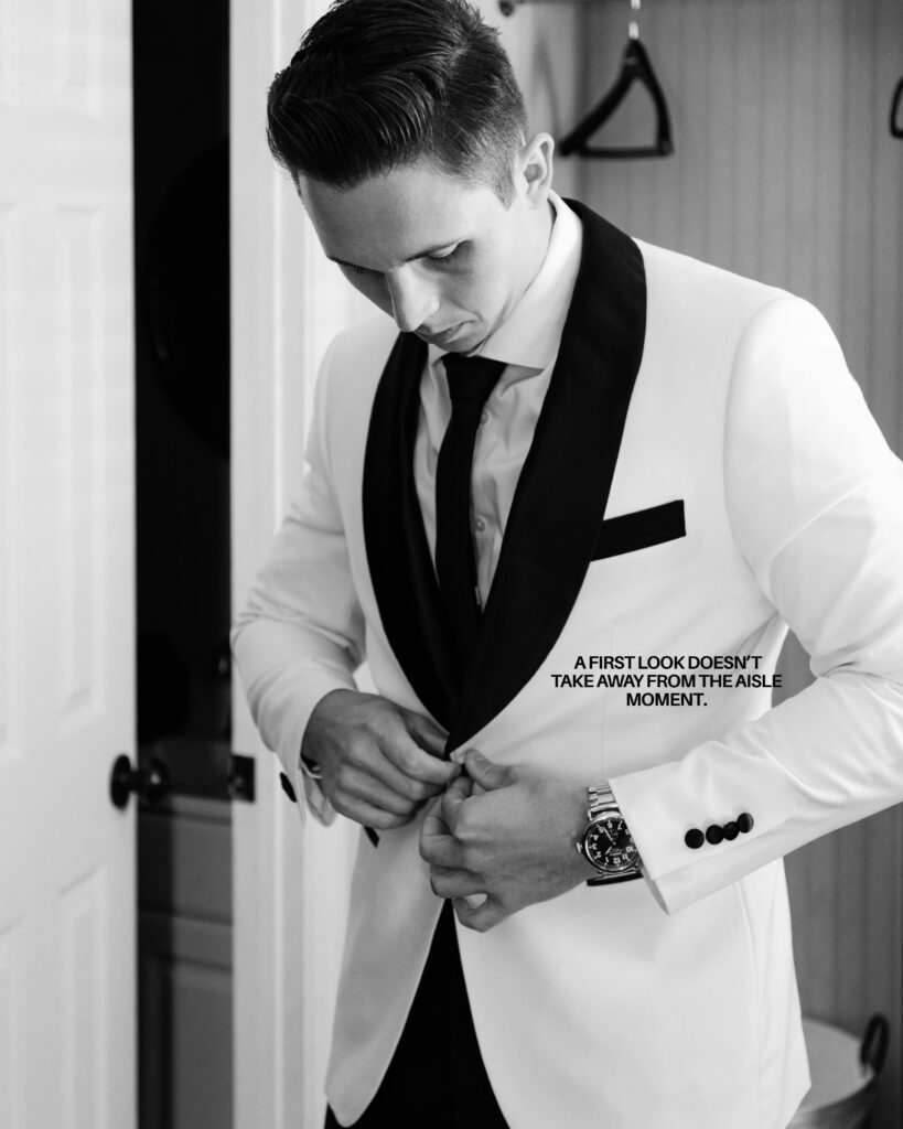 Groom getting ready for the first look in a white dinner jacket suit doing up the button in Charleston
