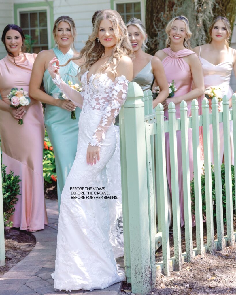 A bride surrounded by her bridesmaids in pinks and greens at a fence at Hewitt Oaks