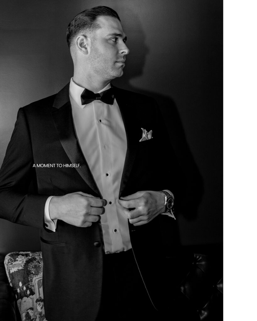 Groom buttoning his black tuxedo