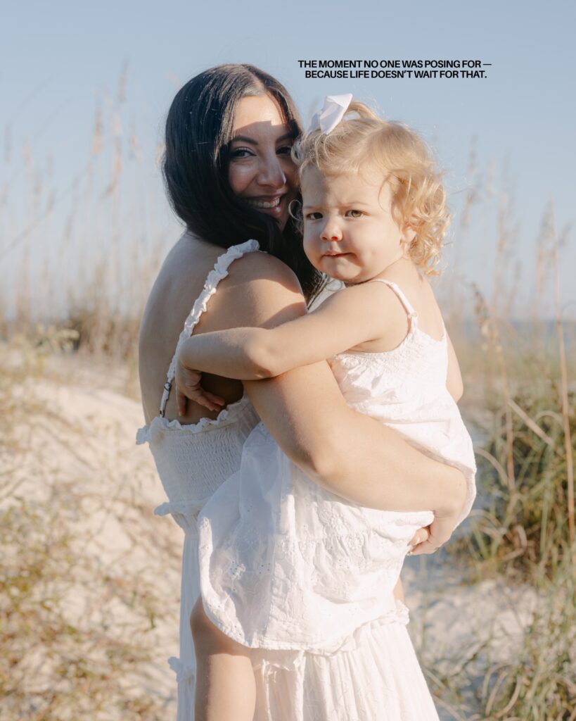 A little girl jumping in the air with her tongue sticking out on the beach in Hilton Head wearing a cute white sundress