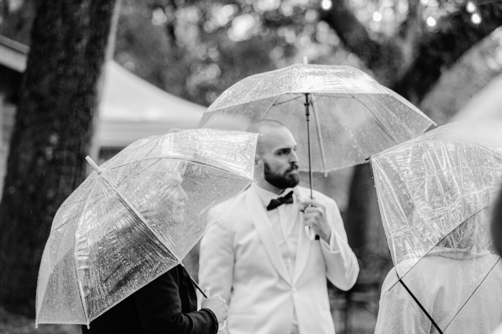 Bride and groom and wedding party out in the rain for photos and fun 