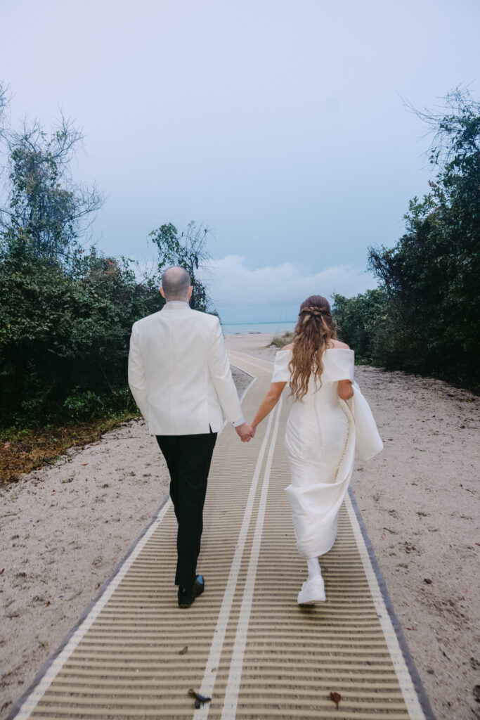 Bride and groom on a rainy day wedding after their ceremony having a great time hugging and kissing and smiling after the ceremony as he lifts her in the air