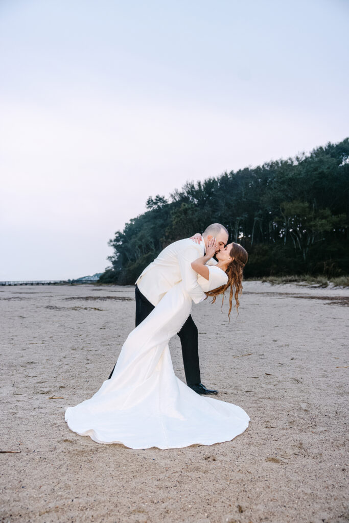 Bride and groom running, playing and kissing on the beach in the rain in Hilton Head