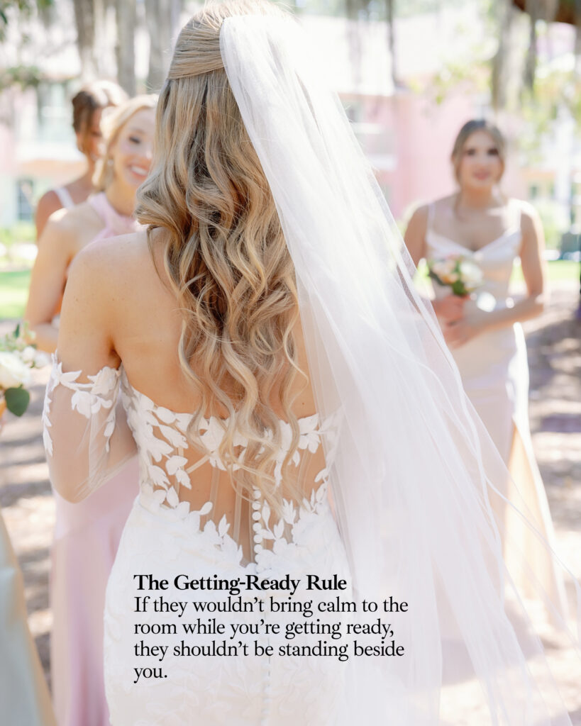 The back shot of a bride with a veil looking on to her bridesmaids at Hewitt Oaks