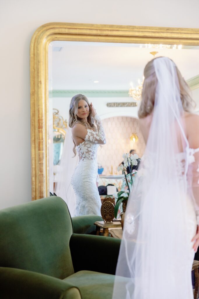 bBride getting ready at Hewitt Oaks looking at hr reflection in the mirror