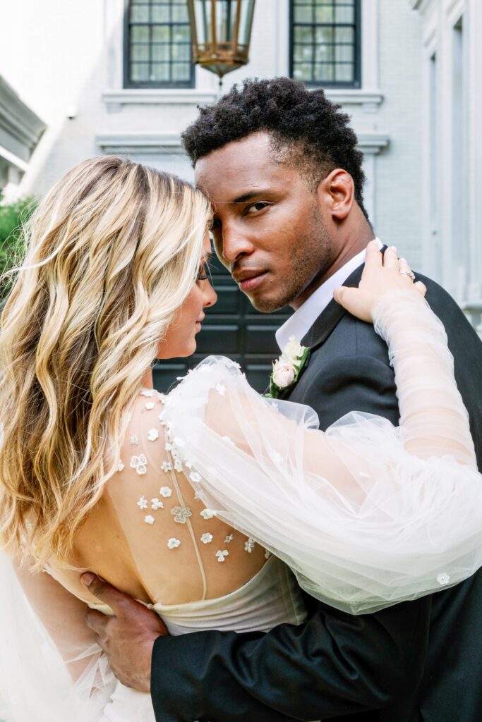 Groom looking over brides shoulder in Savannah at the Kessler Armstrong Mansion