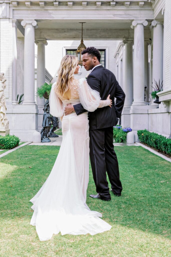 A couple embracing outside of the Armstrong Kessler Mansion in Savannah