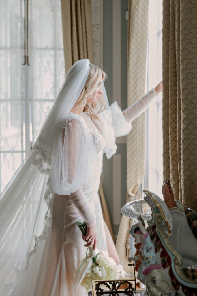 A beautiful bride standing at the window at the Armstong Kessler Mansion in Savannah