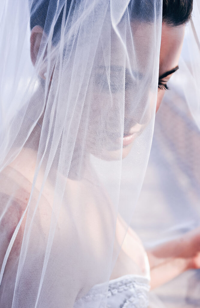 Beaufiful bride with a veil on looking down peacefully on her wedding day